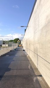 Gereinigte Sichtbetonwand am S-Bahnhof Diebsteich in Hamburg nach der Graffitientfernung, aufgenommen in perspektivischer Ansicht entlang der Bahnsteiganlage.
